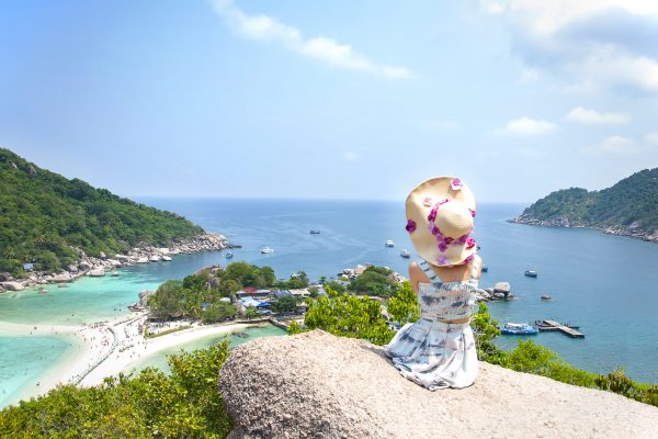 Asian woman sitting on stone in Amazing View point in Nangyuan Island.